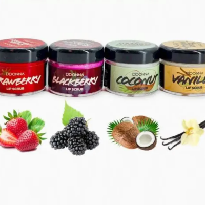 Quatro frascos pequenos de lip scrub DDONNA com sabores morango, amora, coco e baunilha sobre fundo branco