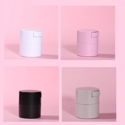 Quatro frascos cilíndricos coloridos em fundo rosa