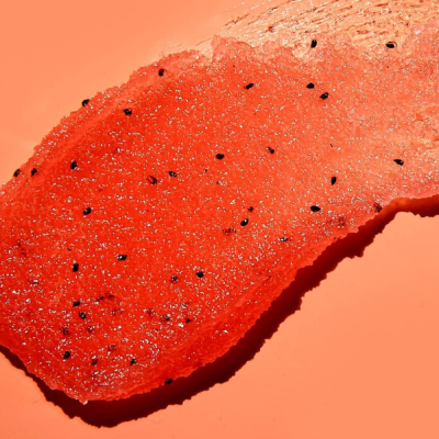Fatia vermelha com sementes pretas sobre fundo alaranjado