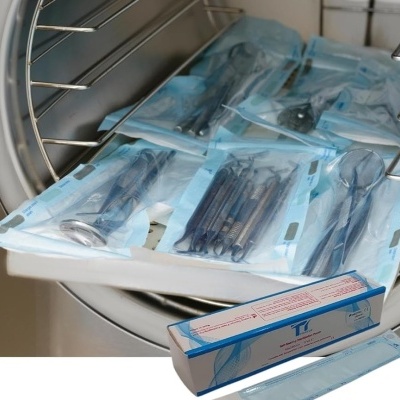Instrumentos dentários esterilizados em autoclave com embalagens e caixa azul.