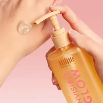 Frasco amarelo com doseador de creme translúcido em gel aplicado na mão