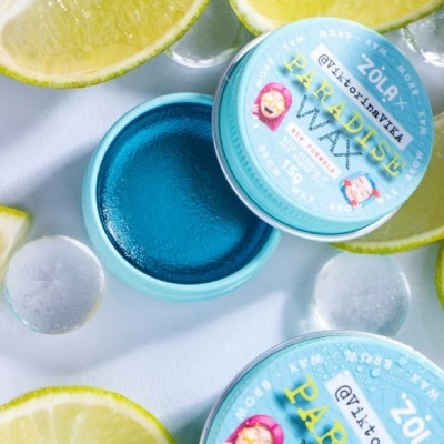 Frasco de cera para cabelo azul com rótulo e limões ao redor