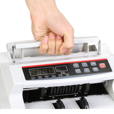 Máquina contadora de notas branca com painel digital e mão a segurar a pega