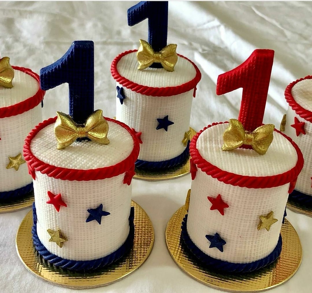 Bolos pequenos decorados com estrelas coloridas e números 1 no topo