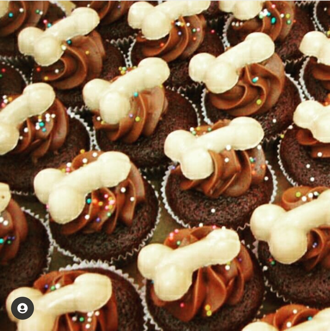 Cupcakes com cobertura de chocolate, granulados coloridos e biscoitos brancos em forma de osso