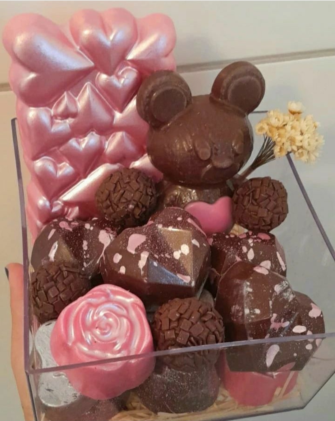 Caixa transparente com chocolates em forma de urso, corações e trufas cor-de-rosa e castanho