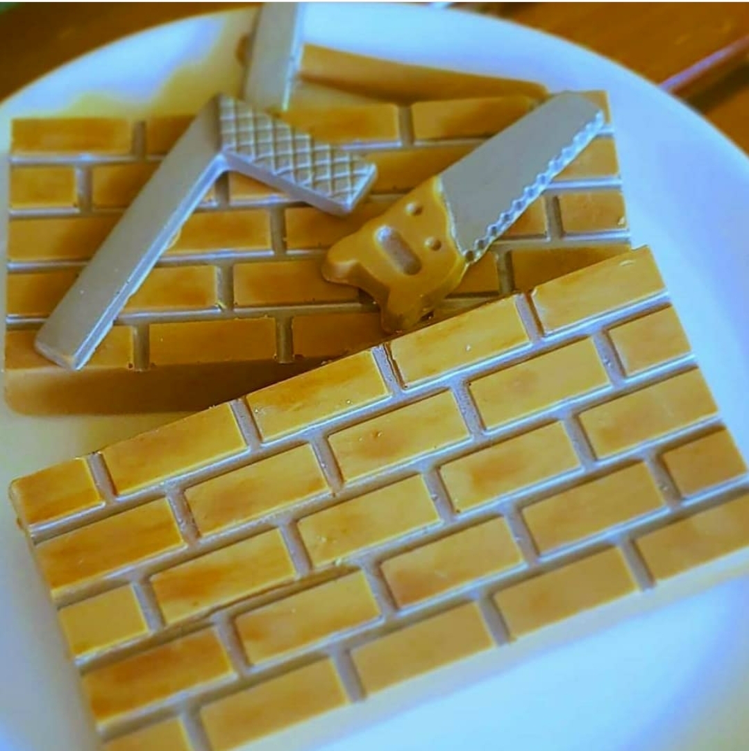 Ímanes decorativos de tijolos em madeira clara com régua e serra no prato branco