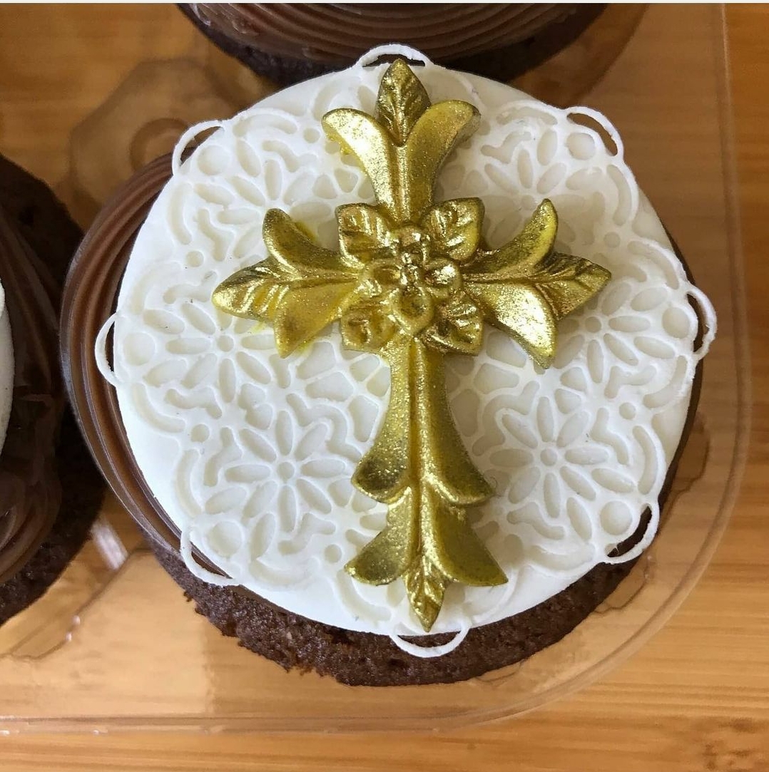 Bolo de chocolate com cobertura branca e cruz dourada decorativa