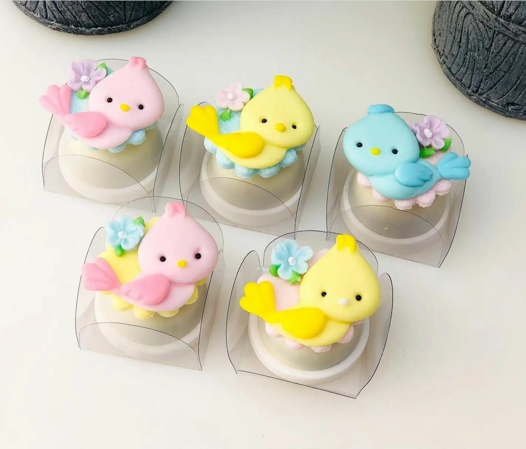 Artigos decorativos de passarinho em açúcar colorido com flores lilases