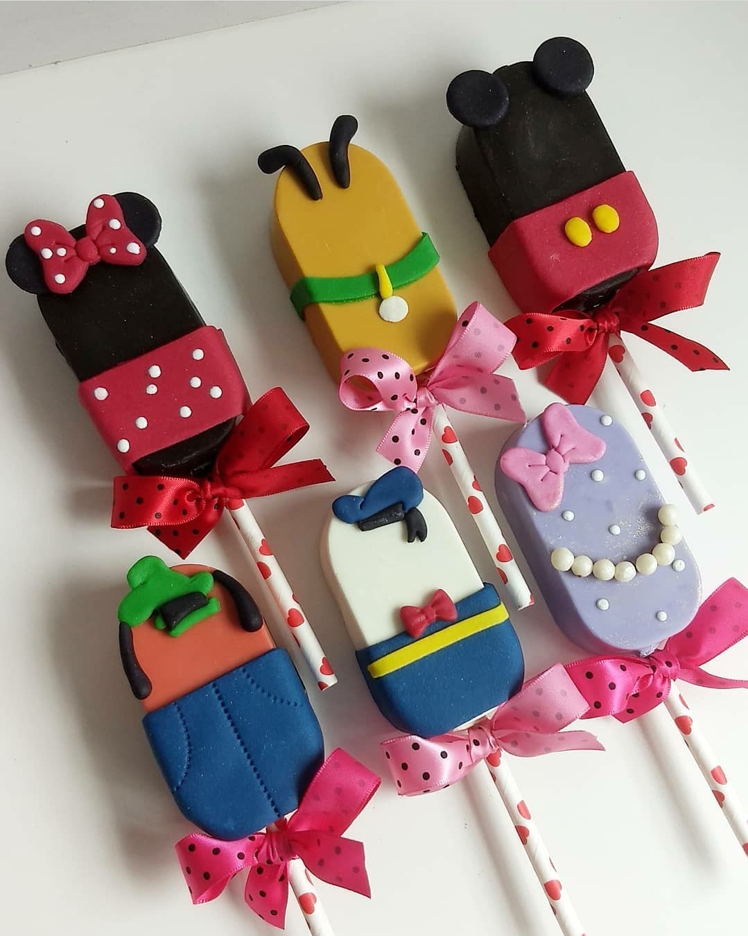 Pirulitos decorados como personagens Disney com laços coloridos