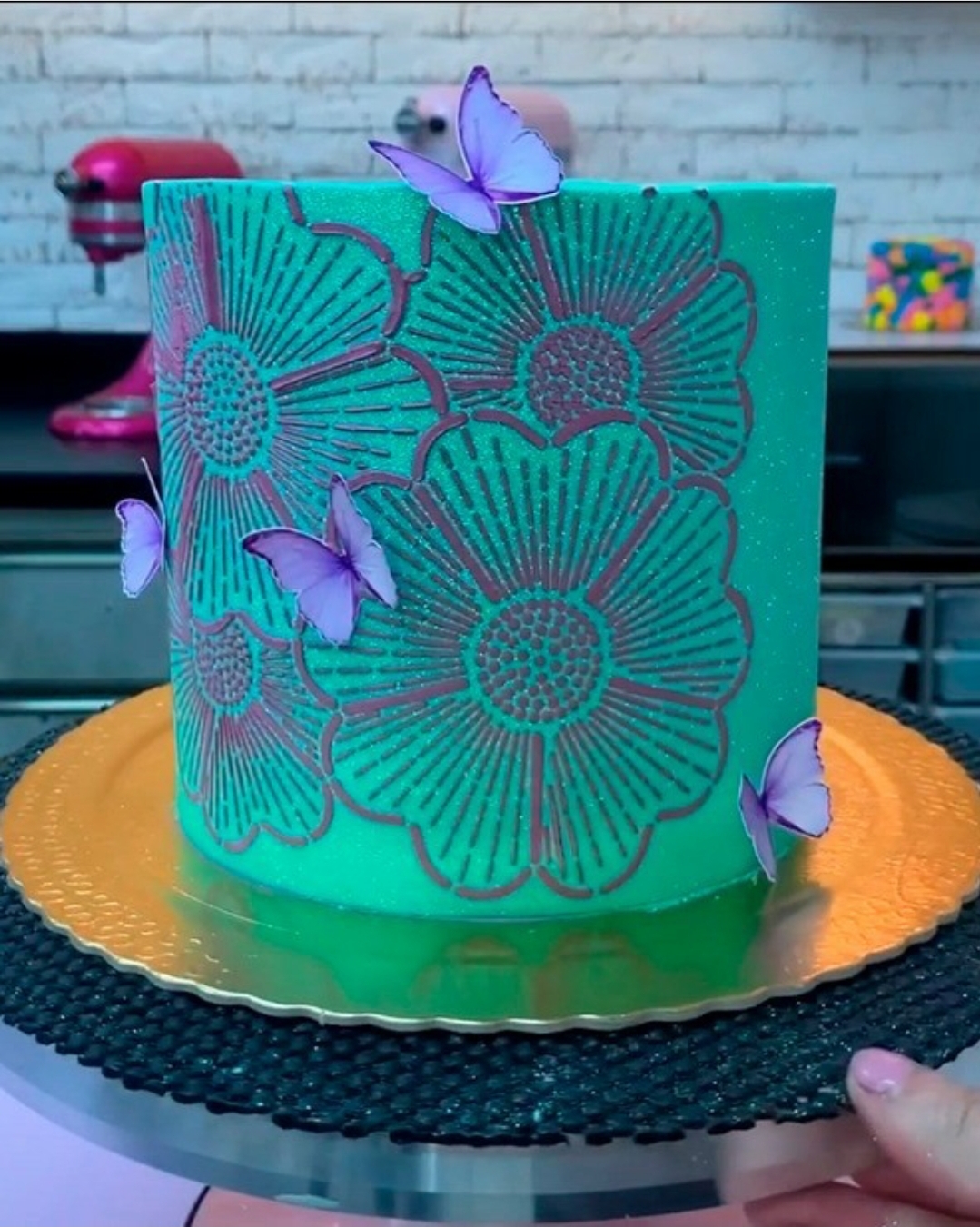 Bolo verde turquesa com decoração prateada de flores e borboletas lilás