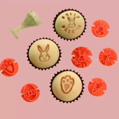 Muffins decorados com carimbos laranja sobre fundo rosa