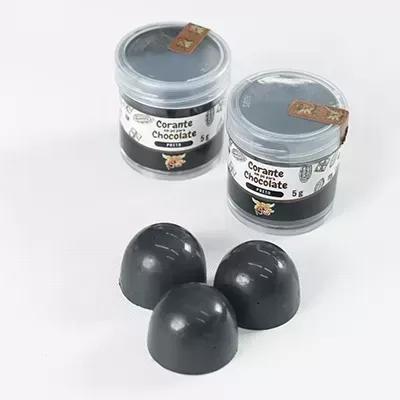 Dois frascos de corante chocolate e três bombons pretos brilhantes em fundo branco