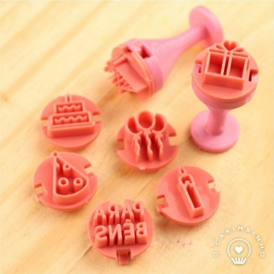 Conjunto de carimbos de borracha rosas com temas variados sobre madeira