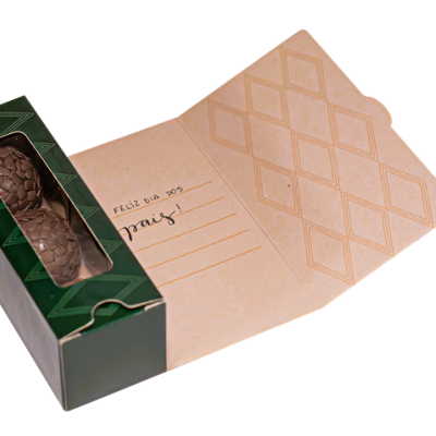 Caixa verde com bombons de chocolate escuro visíveis e tampa aberta com padrão de losangos