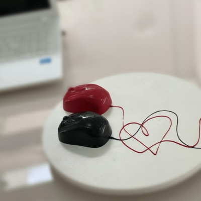 Dois ratos de computador vermelho e preto sobre superfície branca redonda