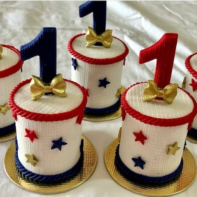 Bolos pequenos decorados com estrelas coloridas e números 1 no topo