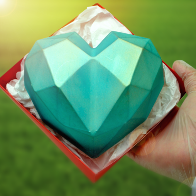 Chocolate azul em forma de coração geométrico numa caixa vermelha com tecido branco