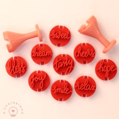 Carimbos de silicone vermelhos com palavras positivas e bases cor-de-rosa