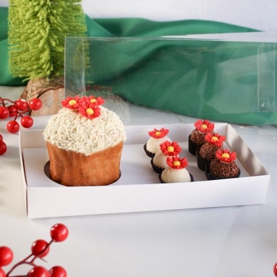 Caixa branca com bolo decorado e brigadeiros, cada um com flor vermelha de açúcar em cima