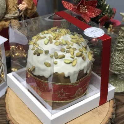 Bolo decorado em caixa transparente com fita vermelha sobre base branca