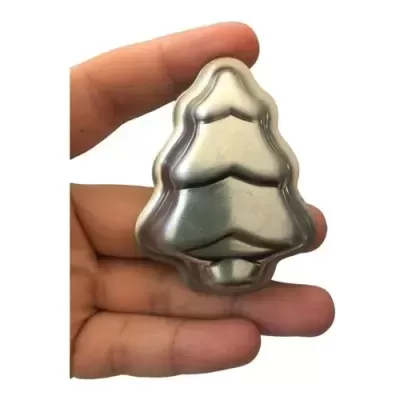 Mini forma de metal prateado em forma de árvore de Natal segurada por uma mão