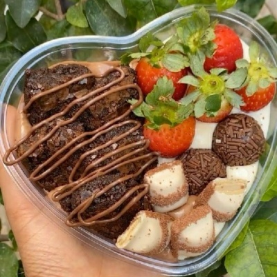 Caixa de sobremesas variadas em forma de coração, com brownies, morangos, brigadeiros e pedaços de chocolate
