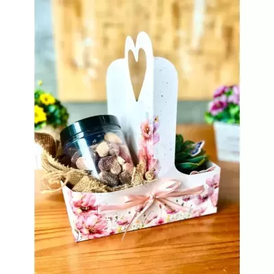 Conjunto de presente com suporte branco decorado com flores e laço com frasco de doces