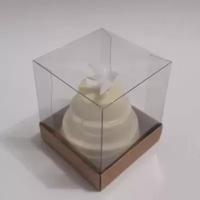 Vela branca em forma de bolo com embalagem transparente