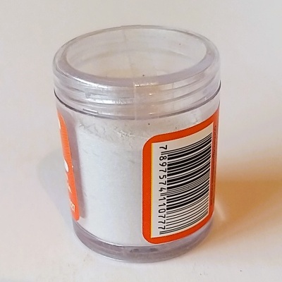 Frasco pequeno transparente com pó branco e etiqueta laranja