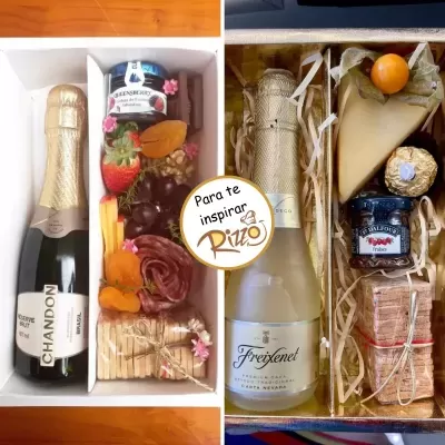 Dois conjuntos de presentes com espumante, frutas, queijo e chocolates em caixas organizadas