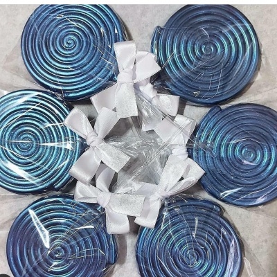 Seis pirulitos azuis espiralados com laços brancos em forma de círculo