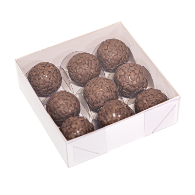 Caixa branca com nove bombons de chocolate decorados em fundo branco
