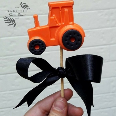 Palito decorativo com figura de trator laranja e fita preta