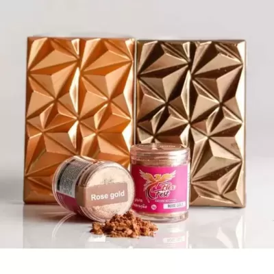 Dois blocos metalizados cobre e dourado com padrão geométrico e dois frascos de pó decorativo rosa Star West