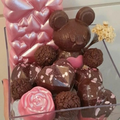 Caixa transparente com chocolates em forma de urso, corações e trufas cor-de-rosa e castanho