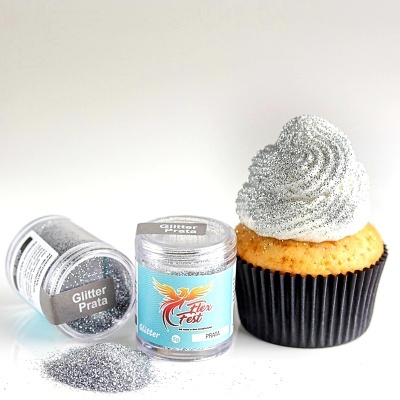 Frascos de glitter prata ao lado de cupcake com cobertura branca e glitter prateado