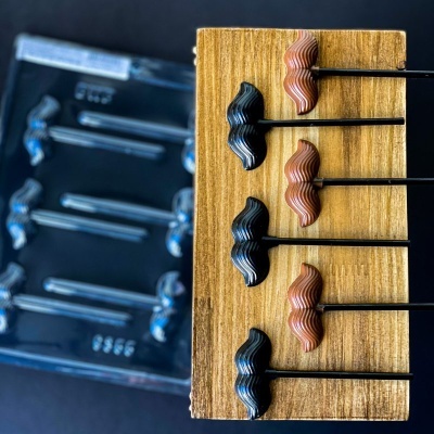Palitos de metal com cabos em forma de bigode em base de madeira