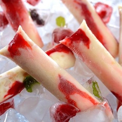 Palitos de gelado branco com manchas vermelhas sobre gelo