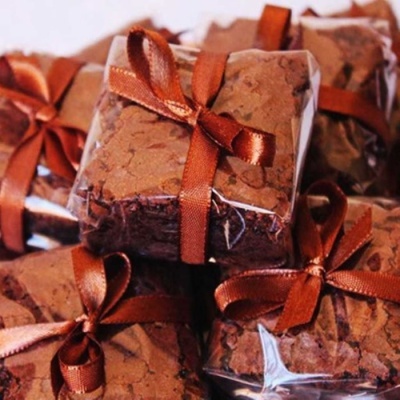 Brownies quadrados embrulhados em plástico com laços de fita castanha