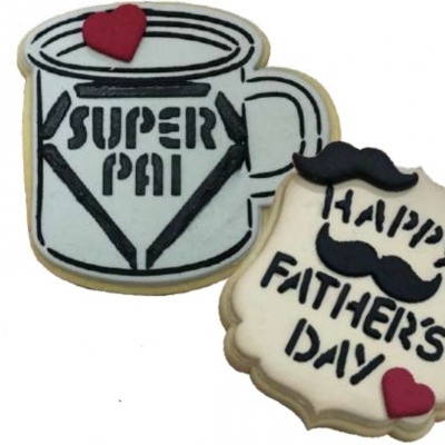Dois biscoitos decorados para o Dia do Pai, um em forma de caneca e outro com texto especial.