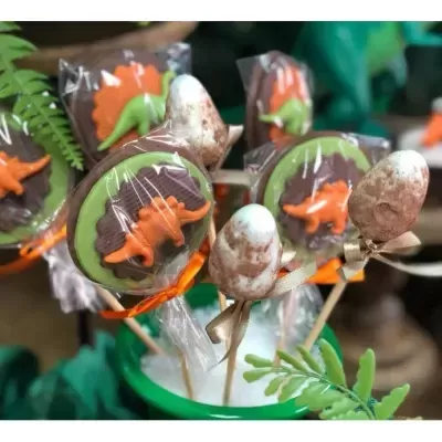 Pirulitos decorativos de dinossauros em embalagem transparente com fitas coloridas