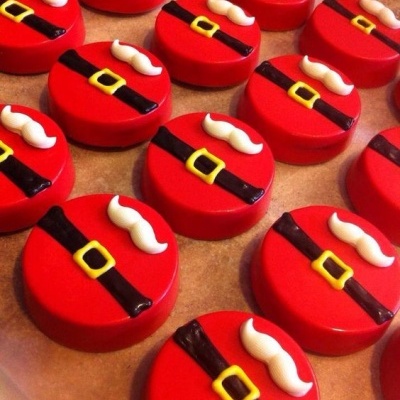 Biscoitos decorados com motivo de cinto e bigode em tons vermelhos, pretos, amarelos e brancos