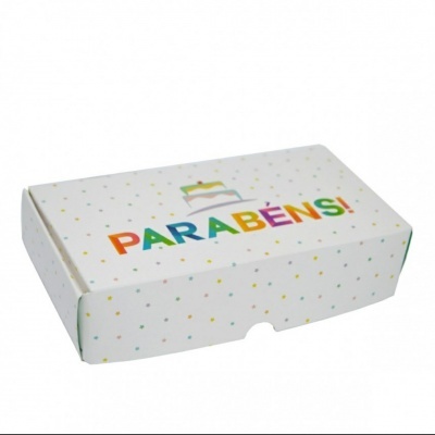 Caixa branca com pontos coloridos e texto 'PARABÉNS!' com bolo