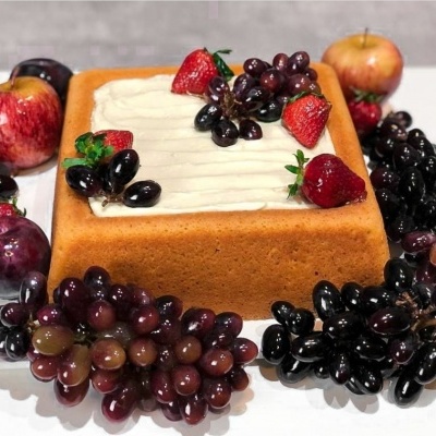 Bolo quadrado com cobertura branca decorado com frutas frescas