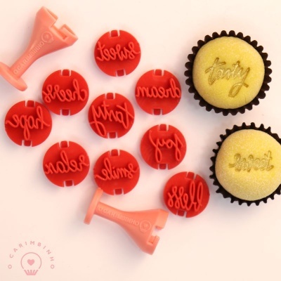Conjunto de carimbos para bolos vermelhos com palavras em inglês e dois cupcakes com cobertura amarela