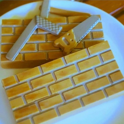 Ímanes decorativos de tijolos em madeira clara com régua e serra no prato branco