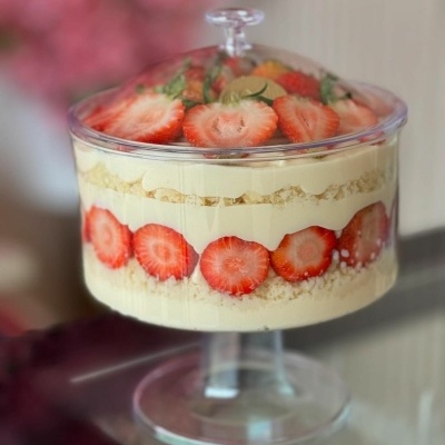 Sobremesa em taça de vidro com camadas de creme e morangos