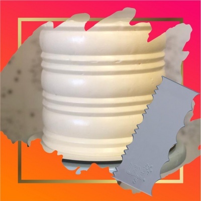 Vaso branco com linhas horizontais e ferramenta cinza serrilhada