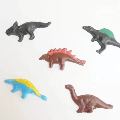 Figuras de dinossauros em plástico colorido sobre fundo branco